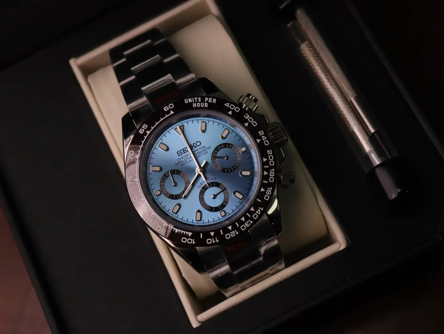 A sleek black seiko chronograph watch with a vibrant blue dial and matching stainless steel bracelet.
