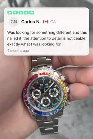 A rainbow-colored bezel surrounds the black dial of this stainless steel rolex daytona watch.